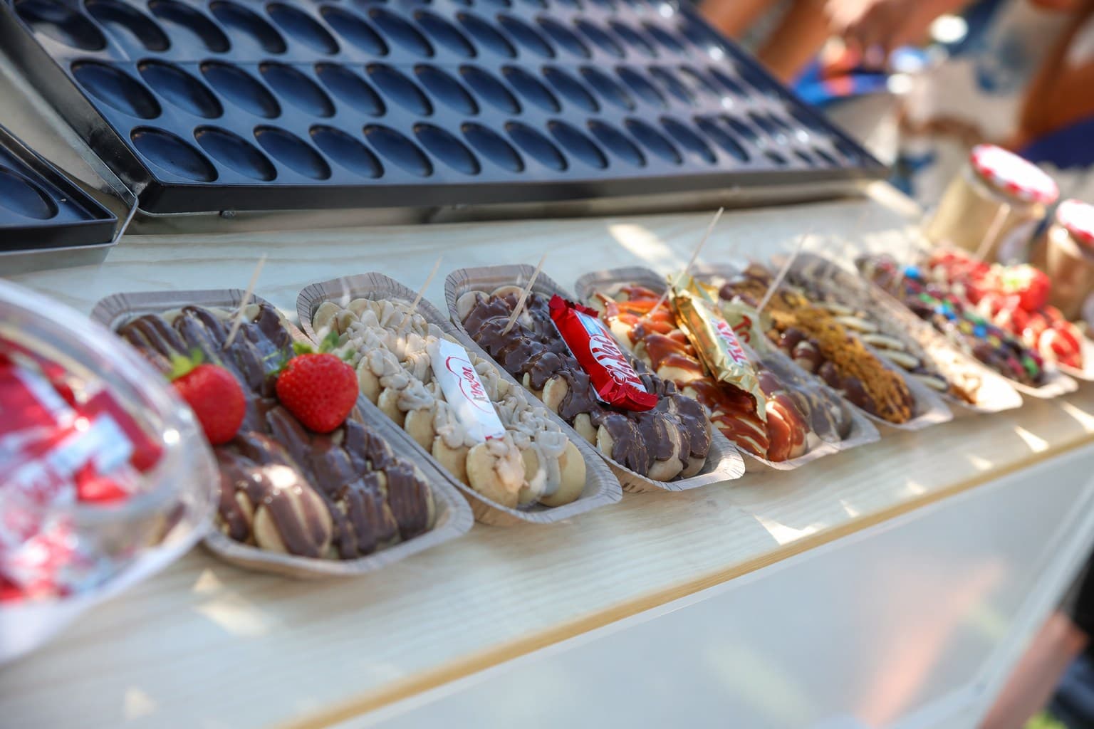 Tabuleiros de mini panquecas com Snickers, Kinder Bueno e Twix, servidos na roulotte