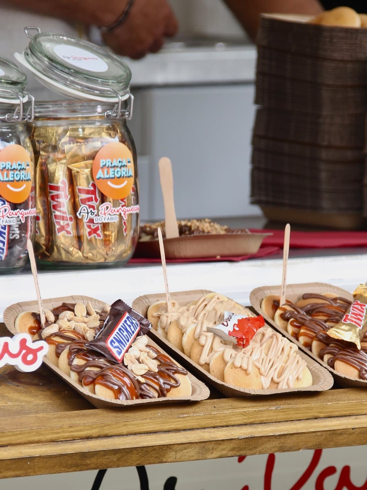 Tabuleiros de mini panquecas com Snickers, Kinder Bueno e Twix, servidos na roulotte